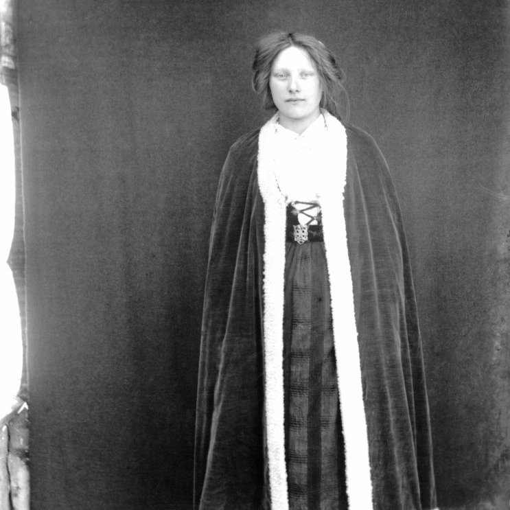 Óþekkt kona í íslenskum búning og er í Möttli yfir. Myndin tekin um 1889-1920.