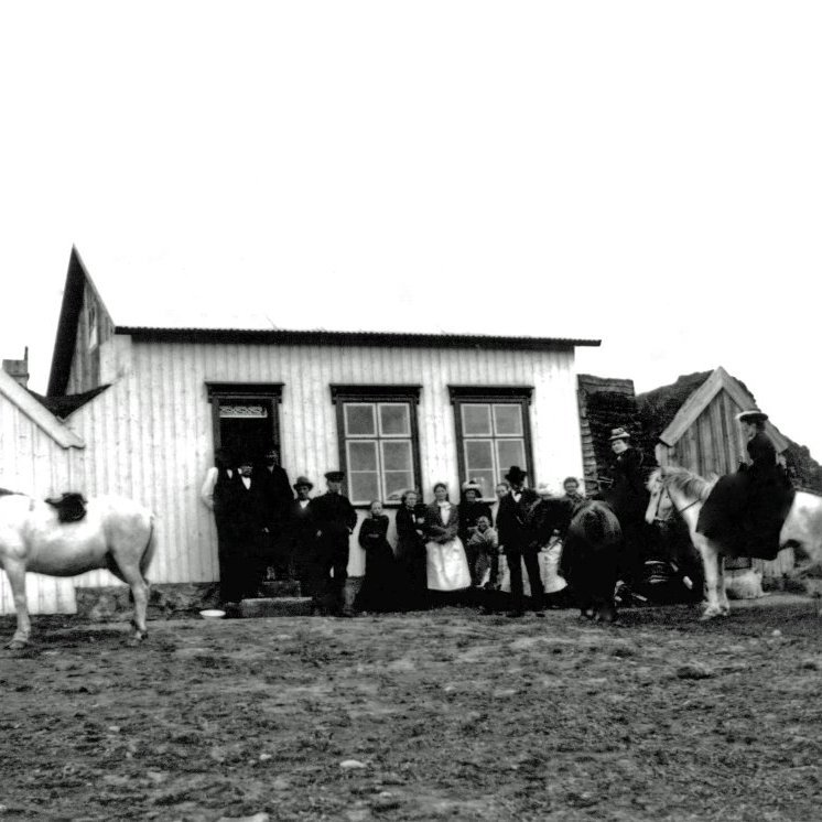 Hópur fólks á bæjarhlaðinu á óþekktum torfbæ. Myndin tekin ca. 1898-1912.