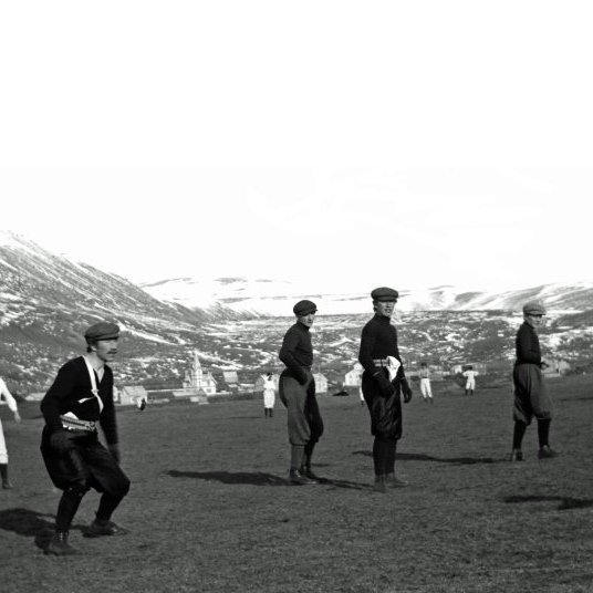 Fótboltaleikur út á Höfða, elsta knattspyrnuvelli Húsvíkinga, þar sem nú er síðar var trésmiðjan Fjalar, áhaldahús bæjarins o.fl. byggingar.Myndin sennilega tekin um 1910. Forvitnilegt er að virða fyrir sér búnina leikmanna og allir eru þeir með derhúfu. Næstur t.v. er Sigurður Bjarklind kaupfélagsstjóri.