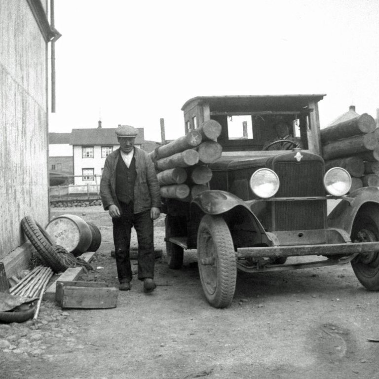 Myndin er tekin á Húsavík 1930.
Marteinn Jónsson á Bjarnarstöðum er búinn að lesta vörubílinn sinn með símastaurum sem eiga að fara í Bárðardalinn.